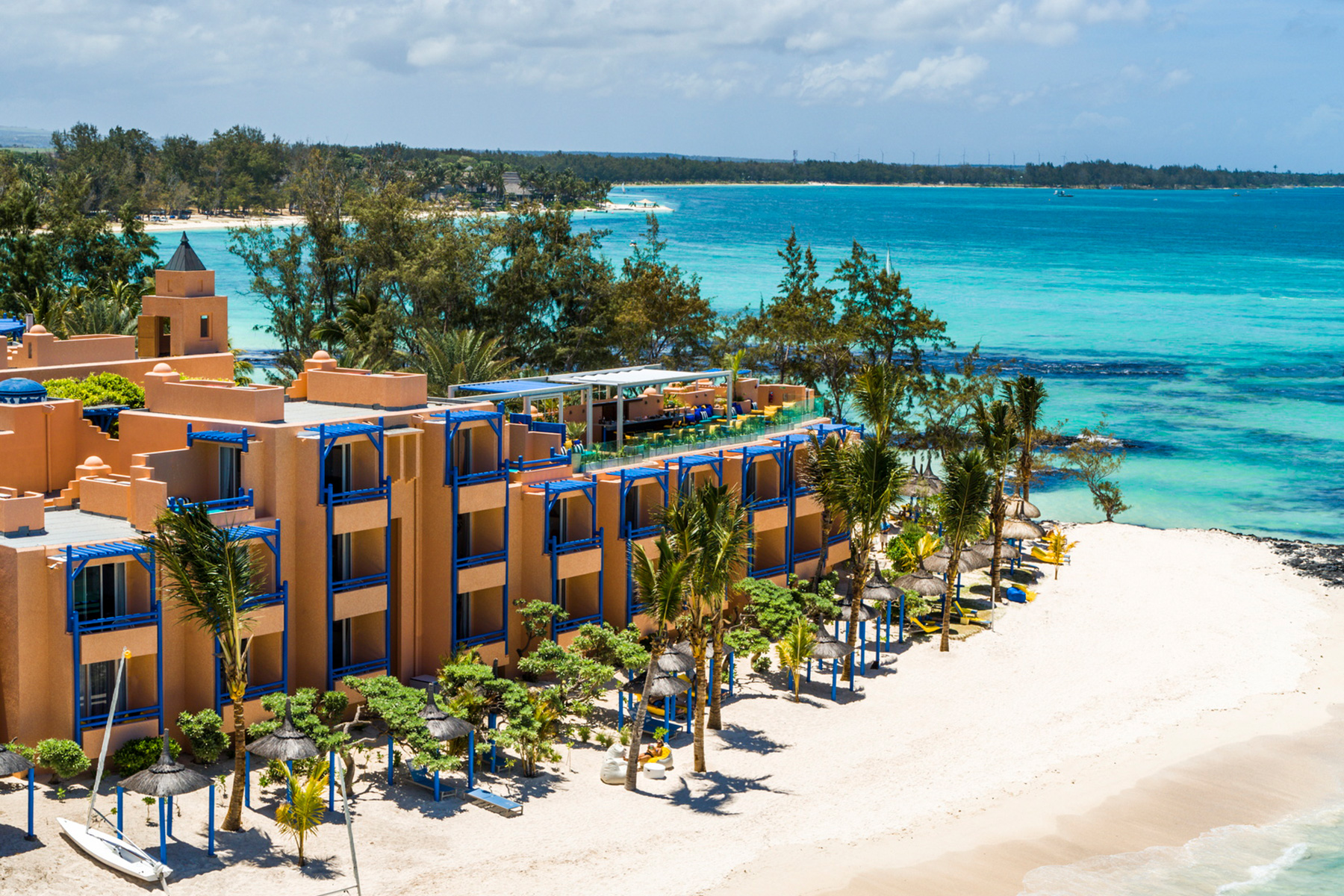 Luxushotel liegt auf Strandzunge mit Palmen
